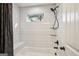 Bright bathroom with a shower and tub combination, featuring white tiling and a window at 429 Burgundy Se Ter, Atlanta, GA 30354