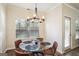 Cozy dining area featuring a modern chandelier, glass table top, and comfortable chairs at 429 Burgundy Se Ter, Atlanta, GA 30354