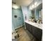 Elegant bathroom with dual sinks, light blue walls, and gray cabinetry at 504 Plantation Creek Dr, Loganville, GA 30052