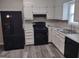 Kitchen boasts white cabinets, black appliances, and grey flooring at 5495 Reynolds Rd, Morrow, GA 30260