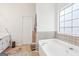 Bathroom with soaking tub, tile flooring and window at 718 Grove Pointe Cir, Locust Grove, GA 30248
