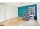 Spacious bedroom with teal accent wall and a window overlooking the backyard at 718 Grove Pointe Cir, Locust Grove, GA 30248