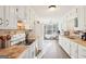 Bright kitchen with white cabinets, wood-look flooring, and stainless steel appliances at 718 Grove Pointe Cir, Locust Grove, GA 30248