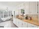 Kitchen features white cabinets, tile backsplash, and a window overlooking the backyard at 718 Grove Pointe Cir, Locust Grove, GA 30248