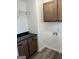 Bright laundry room with dark wood cabinets and granite countertop at 95 Pin Oak Trl, Villa Rica, GA 30180