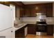 Galley kitchen with dark wood cabinets and stainless steel appliances at 2405 Falls River Dr, Lithia Springs, GA 30122