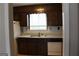 Kitchen with dark wood cabinets, double sink and dishwasher at 2405 Falls River Dr, Lithia Springs, GA 30122