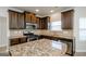 Stylish kitchen boasts stainless steel appliances, granite countertops, and sleek dark wood cabinetry, modern and functional at 5345 Bucknell Trce, Cumming, GA 30028