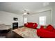Cozy living room with fireplace, plush red couches, and a ceiling fan creates a comfortable atmosphere at 5345 Bucknell Trce, Cumming, GA 30028