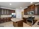 Spacious kitchen with stainless appliances, center island, and dark wood cabinets offer ample storage and workspace at 5345 Bucknell Trce, Cumming, GA 30028