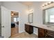 Bathroom with a double vanity with framed mirrors, tile floors, and open doorway to bedroom at 5345 Bucknell Trce, Cumming, GA 30028