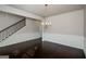 Formal dining room with dark wood floors, wainscoting, chandelier, and staircase at 5345 Bucknell Trce, Cumming, GA 30028