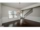 Formal dining area with rich hardwood floors, elegant chandelier, and decorative wainscoting at 5345 Bucknell Trce, Cumming, GA 30028