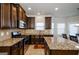 Well-lit kitchen featuring granite countertops, stainless steel appliances, and dark wood cabinets at 5345 Bucknell Trce, Cumming, GA 30028