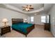 Spacious bedroom with ceiling fan, tray ceiling, carpeted floors, and a large bed at 5345 Bucknell Trce, Cumming, GA 30028