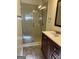 Bathroom with glass shower, dark vanity, and tile floor at 6074 Shallow Wood Ln, Douglasville, GA 30135