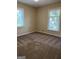 Bright bedroom featuring carpet, two windows, and neutral walls at 6074 Shallow Wood Ln, Douglasville, GA 30135
