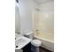 Bright bathroom featuring a white vanity with dark cabinets and a shower-tub combination at 415 Dove Ln, Social Circle, GA 30025