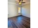Bright bedroom with a modern ceiling fan, wood-look flooring, and natural light from large windows at 415 Dove Ln, Social Circle, GA 30025