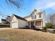 Charming exterior of the home, showcasing a two-car garage and a landscaped front yard at 1535 Valley Club Dr, Lawrenceville, GA 30044