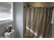 Bathroom with shower, window, and neutral decor at 155 Carriage Gate Dr, Sharpsburg, GA 30277