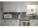 White cabinets, granite countertops and gray tile backsplash at 155 Carriage Gate Dr, Sharpsburg, GA 30277