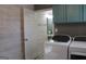 Laundry room with washer, dryer, and teal cabinets at 155 Carriage Gate Dr, Sharpsburg, GA 30277
