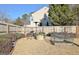 Private backyard featuring a stone fire pit, gravel, mature landscaping, and a wood fence at 704 Pine Grove Cir, Peachtree City, GA 30269