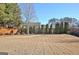 Spacious backyard bordered by a wood fence and mature evergreens to provide maximum privacy at 704 Pine Grove Cir, Peachtree City, GA 30269
