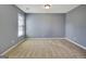 This bedroom features neutral paint, plush carpet, a window, and ample sunlight at 704 Pine Grove Cir, Peachtree City, GA 30269