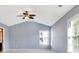 Bright bedroom features neutral paint, vaulted ceilings, plush carpet, ceiling fan and multiple windows at 704 Pine Grove Cir, Peachtree City, GA 30269