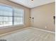 Bedroom with large window, wall-mounted sconces, neutral walls, and carpeting at 704 Pine Grove Cir, Peachtree City, GA 30269