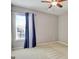 Bright bedroom with a large window, neutral walls, plush carpeting, and a ceiling fan at 704 Pine Grove Cir, Peachtree City, GA 30269