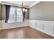 Dining room featuring wood floors, modern chandelier, and large window with decorative curtains at 704 Pine Grove Cir, Peachtree City, GA 30269