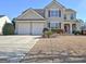 Two-story house with a large yard, two-car garage, and landscaping at 704 Pine Grove Cir, Peachtree City, GA 30269