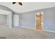 Spacious main bedroom features neutral paint, plush carpet, ceiling fan, and ensuite bathroom at 704 Pine Grove Cir, Peachtree City, GA 30269