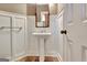 Powder room with pedestal sink, decorative mirror and paneled walls at 704 Pine Grove Cir, Peachtree City, GA 30269
