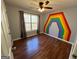 Bedroom with hardwood floors and rainbow wall art at 135 Tuscany Trce, Dallas, GA 30157