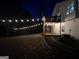 Elevated deck with string lights and a hot tub at night at 135 Tuscany Trce, Dallas, GA 30157