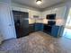 Modern kitchen with dark blue cabinets, granite countertops, and stainless steel appliances at 135 Tuscany Trce, Dallas, GA 30157
