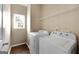 Convenient laundry room with washer, dryer, and overhead shelving at 985 Buckhorn Bnd, Locust Grove, GA 30248