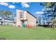 Tan two-story townhouse with green lawn and mature trees at 6036 Regent Mnr, Lithonia, GA 30058