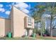Tan two-story townhouse with green lawn and mature trees at 6036 Regent Mnr, Lithonia, GA 30058