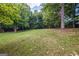 Large grassy backyard with mature trees, offering a serene and private outdoor space at 6667 Ridge Moore Dr, Peachtree Corners, GA 30360