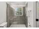Bathroom featuring a glass-enclosed shower with gray tiling and a window at 6667 Ridge Moore Dr, Peachtree Corners, GA 30360