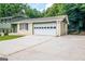 Home exterior featuring attached two-car garage, paved driveway, and manicured lawn at 6667 Ridge Moore Dr, Peachtree Corners, GA 30360