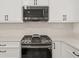 Modern kitchen featuring stainless steel appliances, white shaker cabinets, and quartz countertops at 6667 Ridge Moore Dr, Peachtree Corners, GA 30360