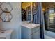 Modern bathroom with dark tile, gray vanity, and bathtub at 2173 Anderson Se Ave, Covington, GA 30014
