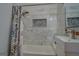 Bathroom with marble tile, bathtub, and a window at 2173 Anderson Se Ave, Covington, GA 30014