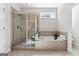 Bright bathroom with a glass enclosed shower, soaking tub, and ceramic tile at 244 Sturry Dr, Mcdonough, GA 30252